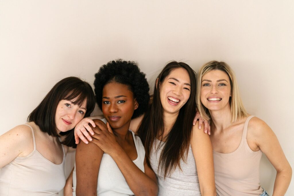 Four smiling women standing close together