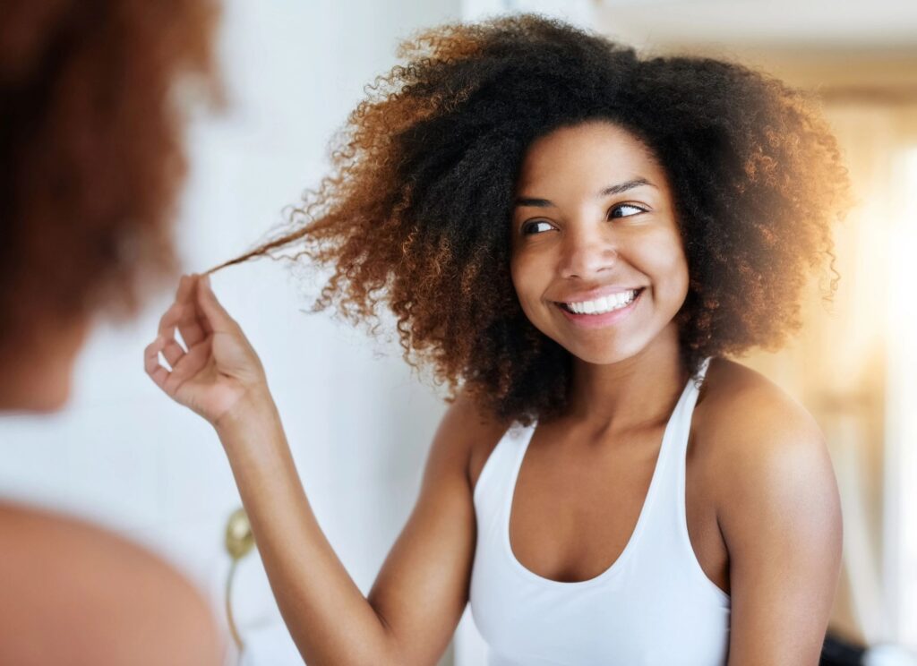 Smiling woman with curly hair looking in mirror